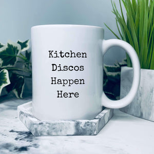 Mug with text on in type writer font that says: Kitchen discos happen here